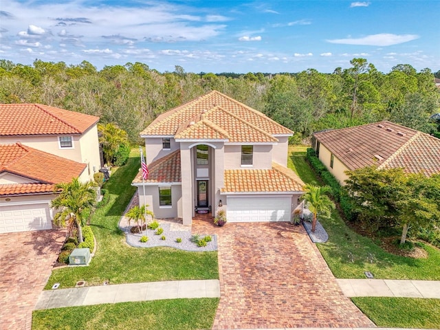 mediterranean / spanish home with a garage and a front yard