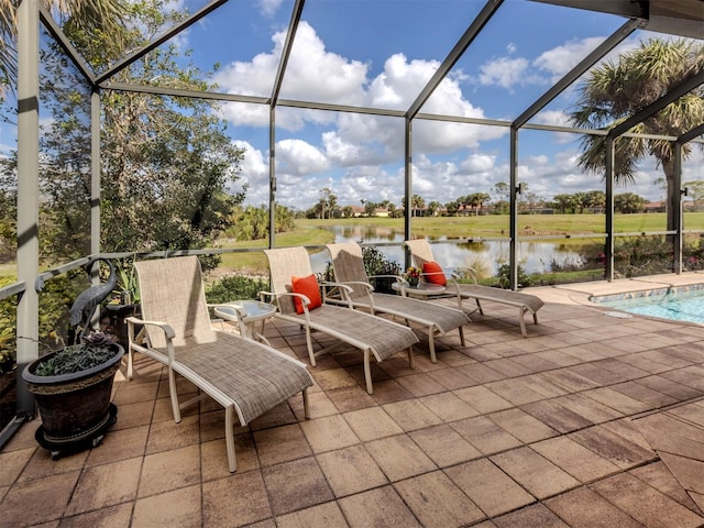 view of patio / terrace featuring glass enclosure, a water view, and an outdoor pool