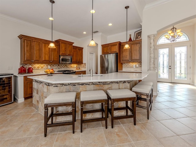 kitchen featuring a spacious island, a breakfast bar, sink, pendant lighting, and stainless steel appliances