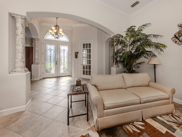 interior space featuring light tile patterned flooring, decorative columns, a chandelier, crown molding, and french doors