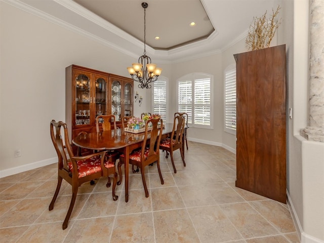 tiled dining area with ornamental molding, a tray ceiling, and a chandelier