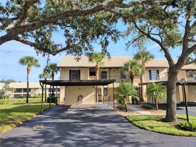 view of front of home with aphalt driveway, a tile roof, and stucco siding