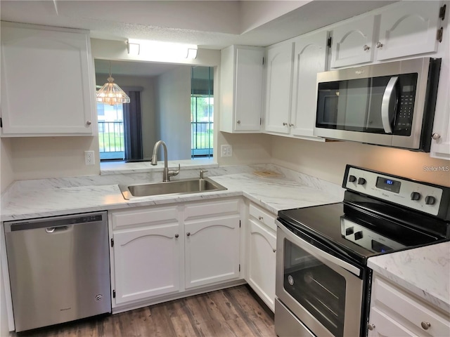 kitchen with white cabinetry, sink, decorative light fixtures, and stainless steel appliances