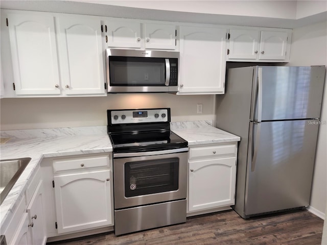 kitchen featuring stainless steel appliances, dark wood-type flooring, and white cabinets