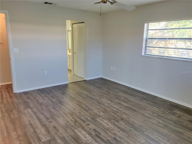 spare room with dark wood-type flooring and ceiling fan