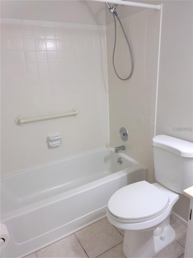 full bathroom with tile patterned flooring, vanity, tiled shower / bath combo, and toilet