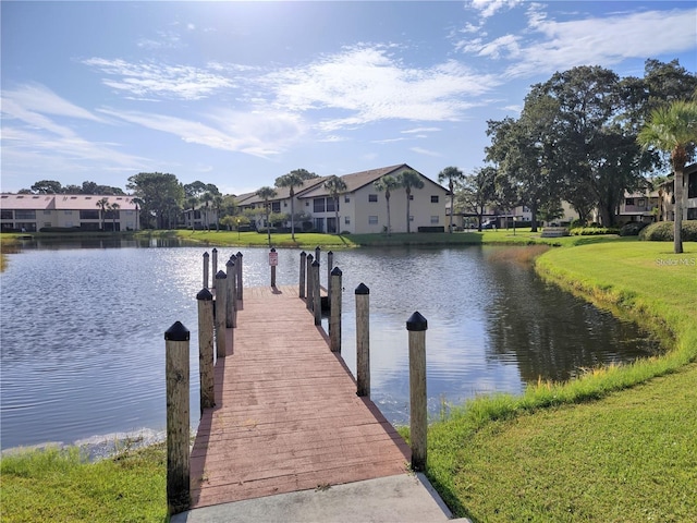 dock area with a water view and a lawn