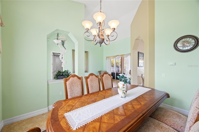 tiled dining space featuring a high ceiling and a notable chandelier