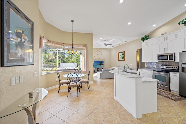 kitchen with sink, appliances with stainless steel finishes, white cabinets, and pendant lighting