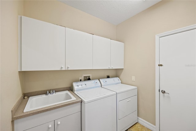 laundry room featuring sink, a textured ceiling, cabinets, and independent washer and dryer