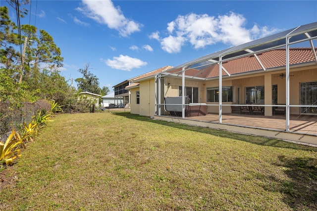 view of yard with ceiling fan, a patio, and a lanai