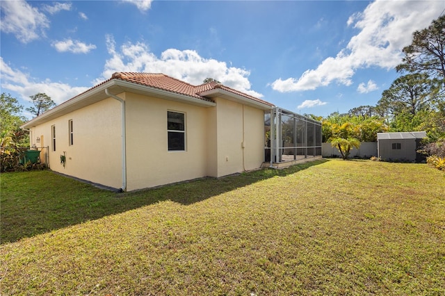 view of side of home featuring a lanai and a lawn