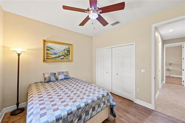 bedroom with light hardwood / wood-style floors, a closet, and ceiling fan