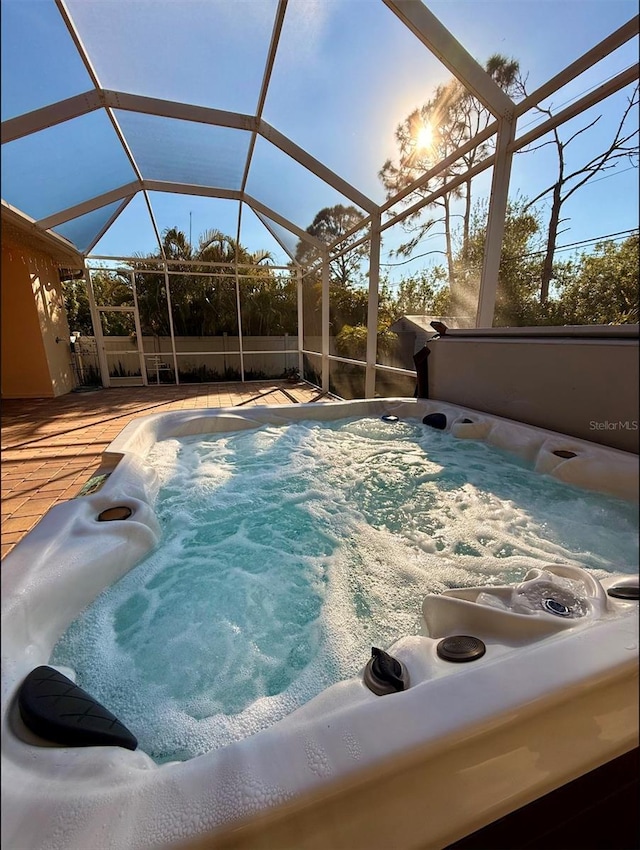 view of swimming pool with glass enclosure and a hot tub