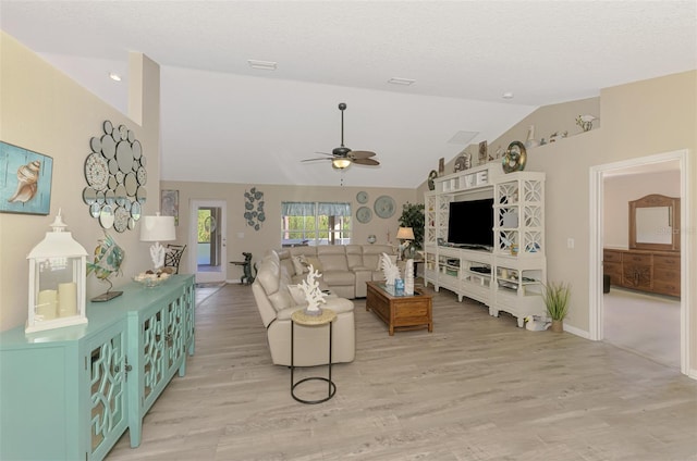 living room with ceiling fan, lofted ceiling, a textured ceiling, and light wood-type flooring