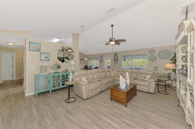 living room featuring a textured ceiling, vaulted ceiling, ceiling fan, and light wood-type flooring