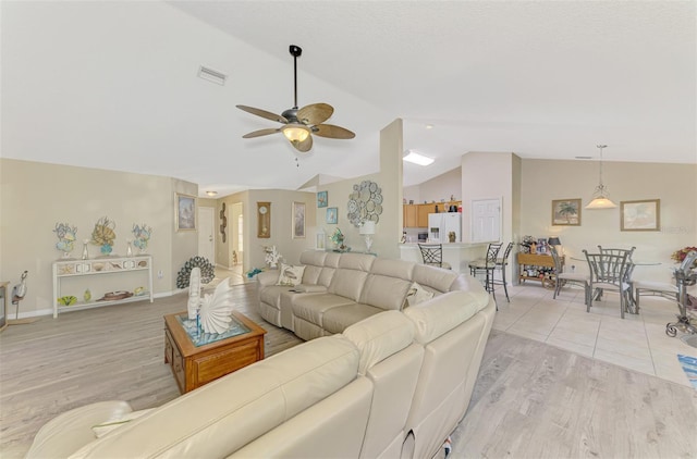 living room featuring lofted ceiling, ceiling fan, and light wood-type flooring