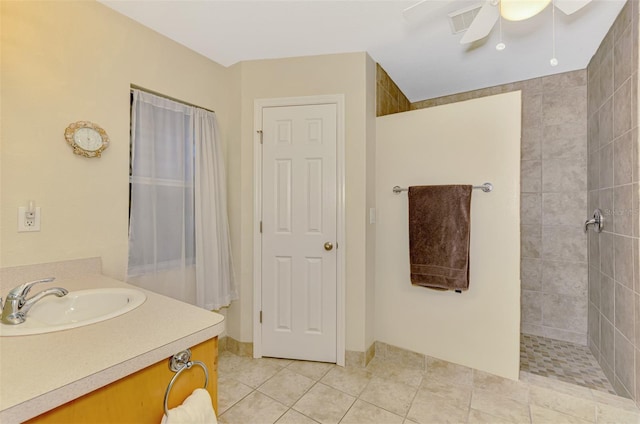 bathroom with ceiling fan, tile patterned floors, vanity, and tiled shower