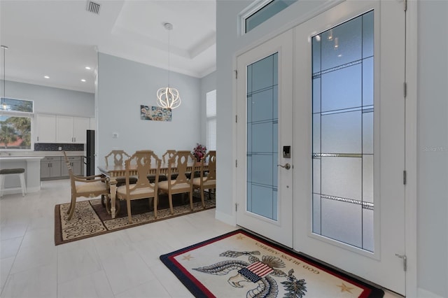 foyer entrance with a tray ceiling and french doors