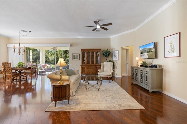 living room with ceiling fan with notable chandelier, dark wood-type flooring, ornamental molding, and a textured ceiling