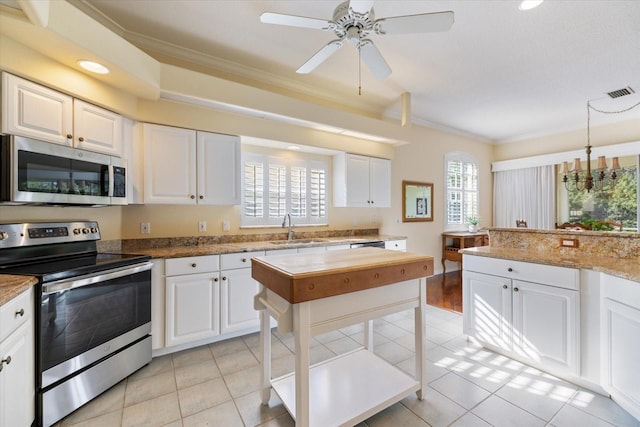 kitchen with stainless steel appliances, sink, pendant lighting, and white cabinets