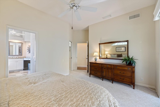 bedroom with light carpet, ensuite bath, and ceiling fan