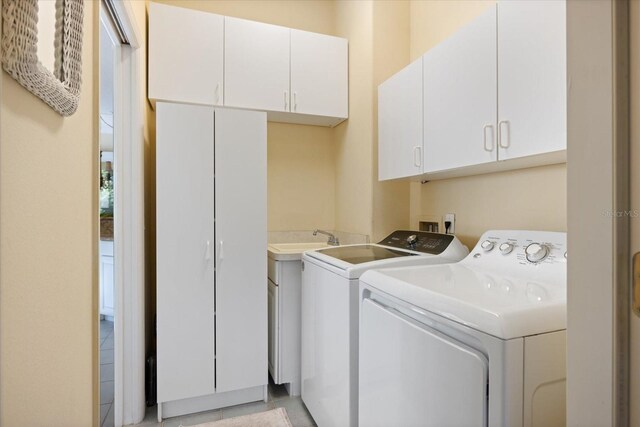 clothes washing area with cabinets and separate washer and dryer