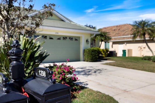 ranch-style house featuring cooling unit and a garage