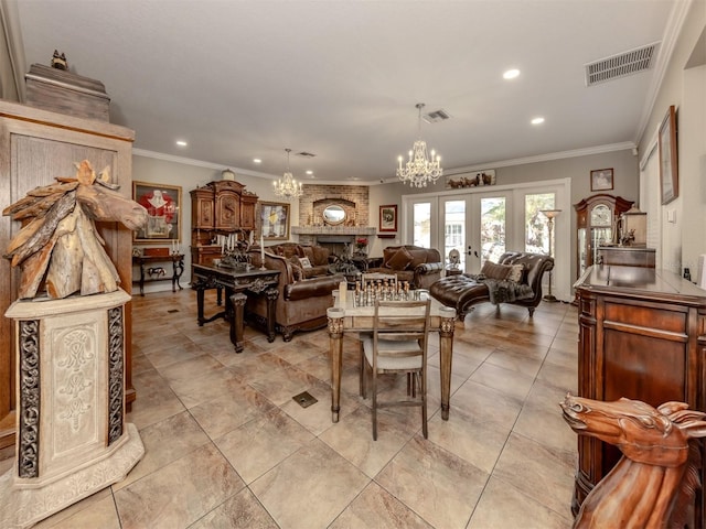 dining area featuring an inviting chandelier, a large fireplace, crown molding, and french doors