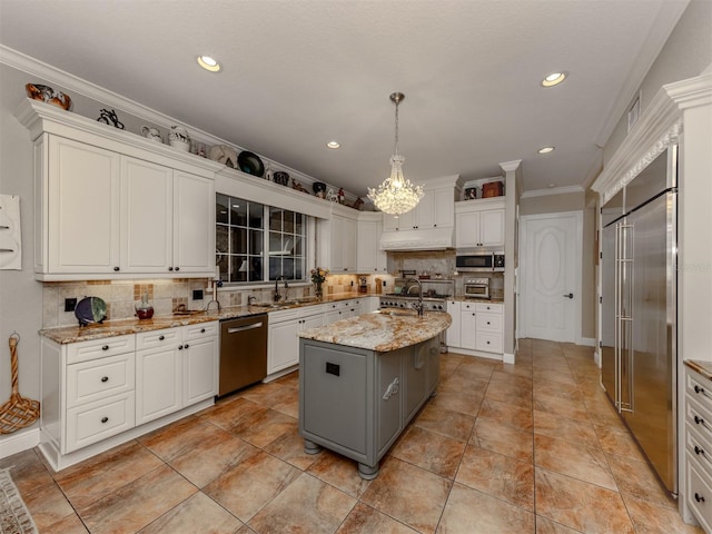 kitchen featuring white cabinetry, hanging light fixtures, stainless steel appliances, light stone counters, and a kitchen island