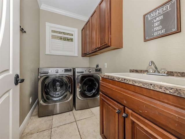 laundry room featuring cabinets, ornamental molding, sink, and washing machine and dryer