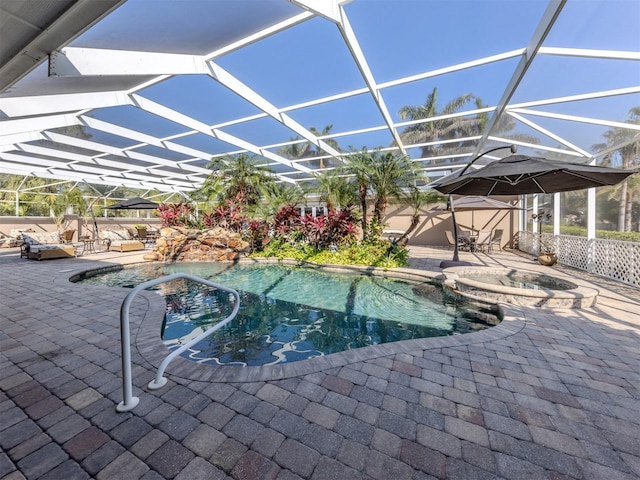 view of pool with an in ground hot tub, glass enclosure, and a patio area