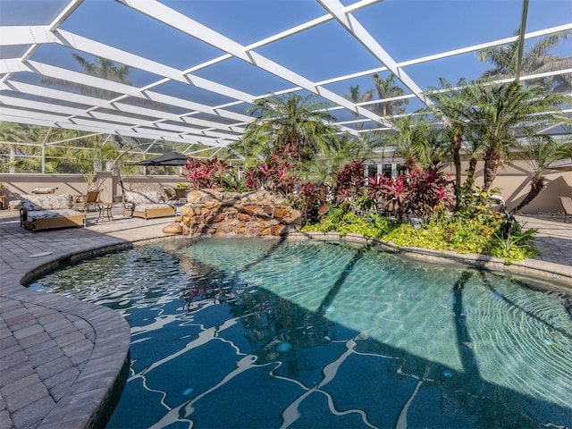 view of pool with a patio area and glass enclosure