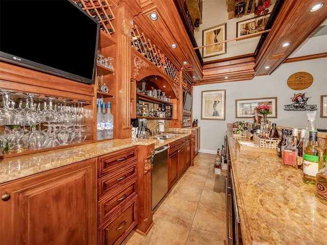 bar featuring dishwasher, sink, ornamental molding, light tile patterned floors, and light stone counters