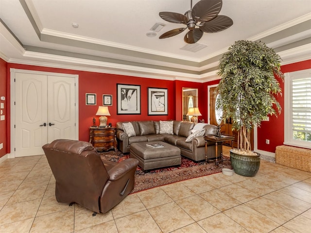 tiled living room featuring ornamental molding, ceiling fan, and a tray ceiling