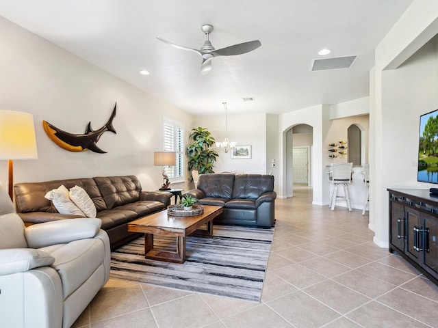 living room with ceiling fan with notable chandelier and light tile patterned floors