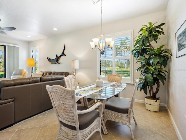 tiled dining area featuring ceiling fan with notable chandelier and a wealth of natural light