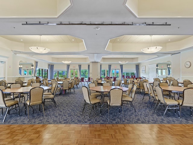 dining room featuring a raised ceiling and parquet flooring