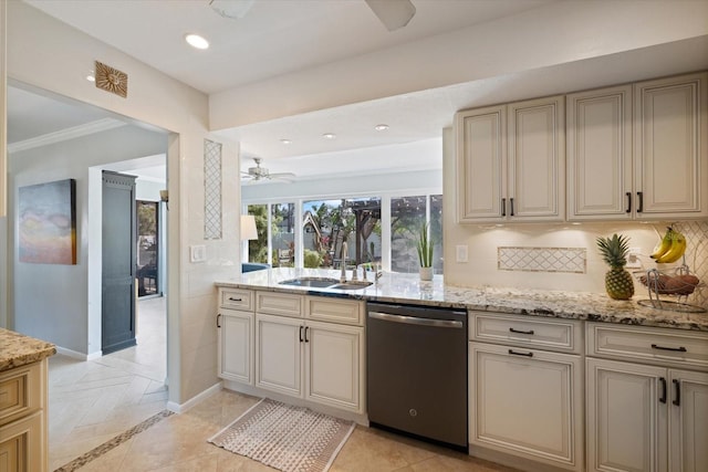 kitchen with light stone counters, cream cabinetry, stainless steel dishwasher, a ceiling fan, and a sink