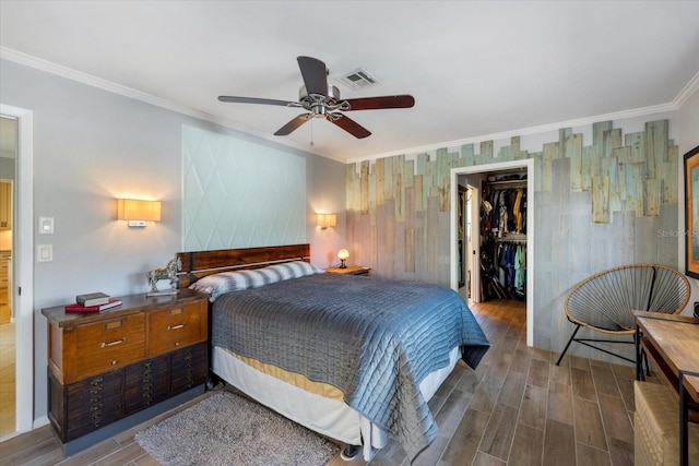 bedroom with visible vents, ornamental molding, a closet, dark wood-style floors, and a walk in closet