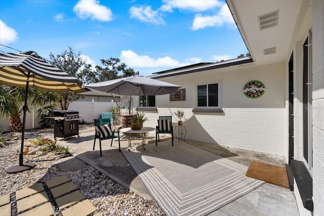 view of patio / terrace with a grill and fence