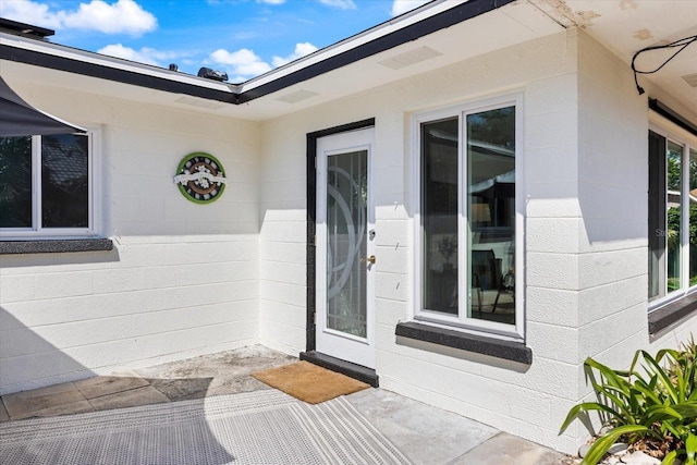 view of exterior entry featuring concrete block siding