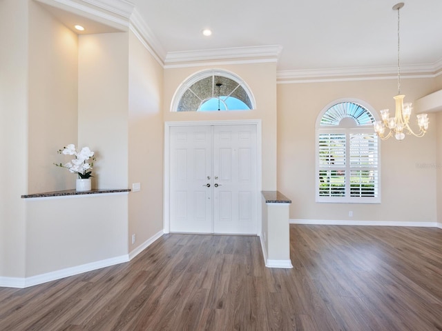 foyer with crown molding, dark hardwood / wood-style floors, and a chandelier