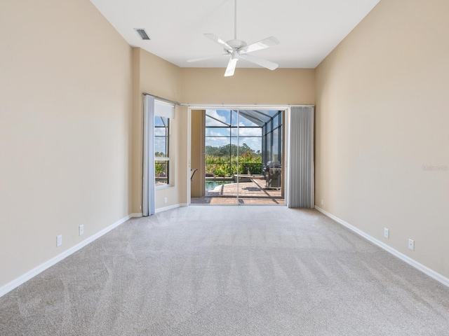 spare room with ceiling fan and light colored carpet