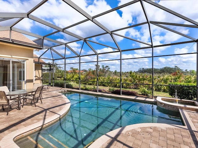 view of pool with a patio, a lanai, and an in ground hot tub