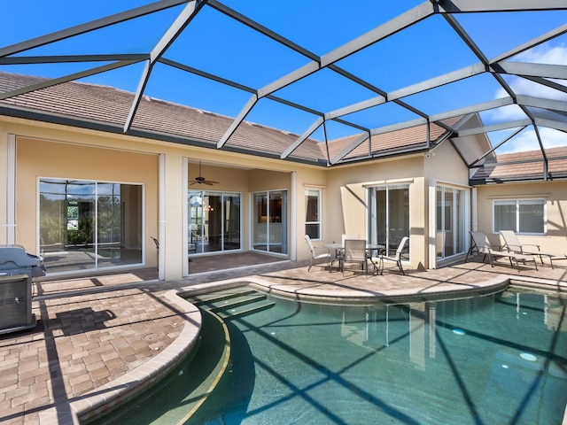 back of property with ceiling fan, a lanai, and a patio