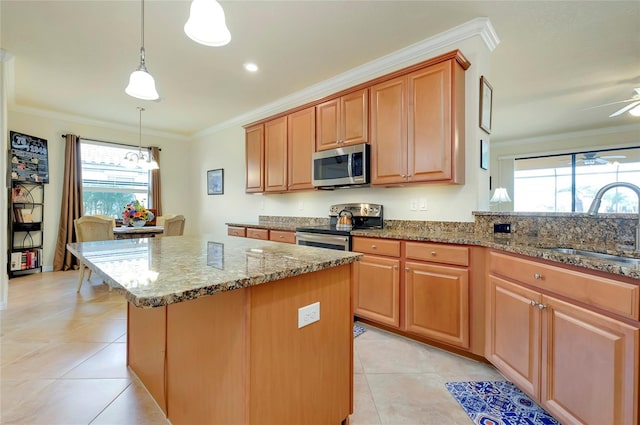 kitchen featuring sink, crown molding, appliances with stainless steel finishes, a kitchen island, and pendant lighting