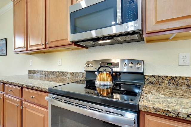 kitchen with appliances with stainless steel finishes and light stone counters