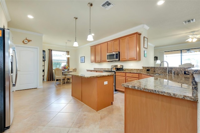 kitchen with pendant lighting, sink, appliances with stainless steel finishes, a kitchen island, and kitchen peninsula