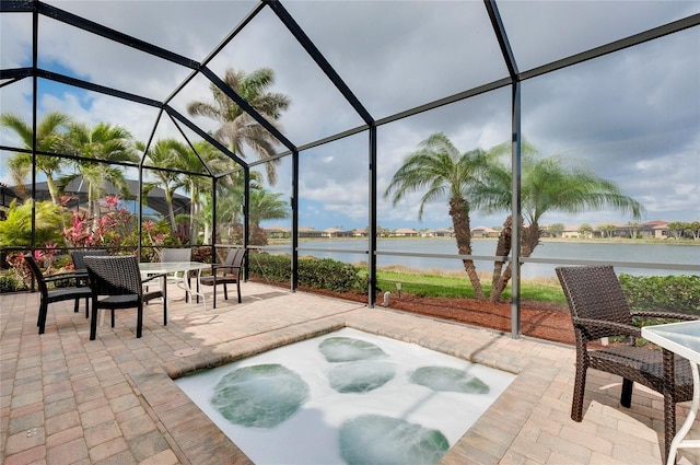 view of patio / terrace featuring a water view and glass enclosure